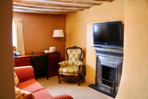 诺丁汉The Cottage Hotel的客厅设有壁炉,上面配有电视。