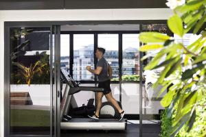 布里斯班亚克安妮公寓式酒店的一个人在健身房跑步机上行走
