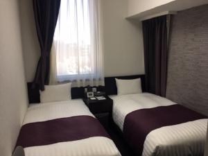 东京上野城市酒店的酒店客房设有两张床和窗户。
