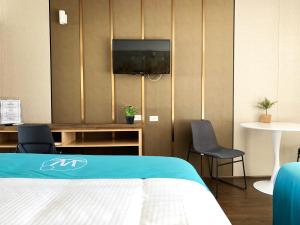 巴特曼斯贝海滨水手酒店的一间卧室配有一张床、一台电视和椅子