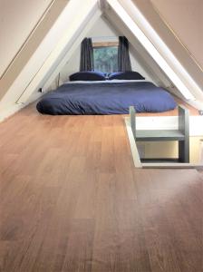 OxfordOxford Tiny House的一间卧室配有一张床,铺有木地板