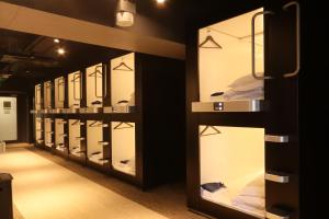 东京Business Capsule Hotel Lightning Hotel Asakusa的镜子室的一排展示盒