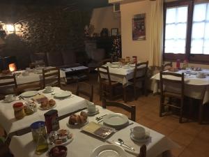 Urtx卡尔梅托乡村民宿的餐厅配有白色的桌椅,提供食物