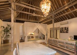 乌鲁瓦图宾艮阿罗哈海滩之家别墅的一间带桌子和床的用餐室