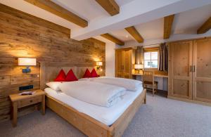 阿尔卑巴赫阿尔卑巴赫盖思福罗斯慕思酒店的一间卧室设有一张大床和木墙