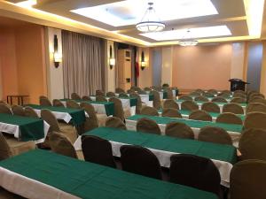 独鲁万洛伦扎酒店的一间会议室,配有绿色和白色的桌椅