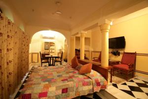 斋浦尔卡图哈维丽酒店的卧室配有一张床和一张桌子及椅子