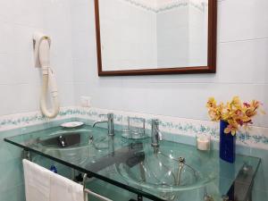 索伦托卡利梅拉别墅公寓的一间带玻璃水槽和电话的浴室