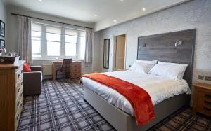 兰迪德诺戈维斯地林克斯酒店的酒店客房设有一张大床和一张书桌。