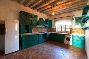 锡德Side Cottagehause的厨房配有绿色橱柜和白色冰箱