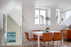 卑尔根Barfot Apartments的一间配备有白色桌椅的用餐室