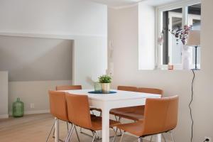卑尔根Barfot Apartments的白色的用餐室配有白色的桌椅