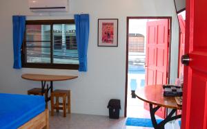 通萨拉Tea Moon Beach House的一间设有桌子和红色门的房间
