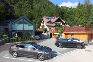 克拉尼斯卡戈拉Vila Edelweiss Rooms&App Kranjska Gora的两辆汽车停在大楼前的停车场