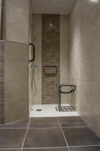 Saint-Paul-lès-Romans卡琳酒店的带淋浴的浴室和玻璃门