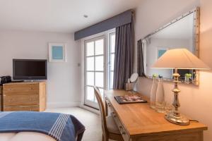 福伊老码头之家酒店 的一间卧室配有一张桌子、一张床和一个窗户