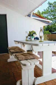 斯泰伦博斯9 on Drommedaris的庭院内一张带软垫椅子的白色桌子