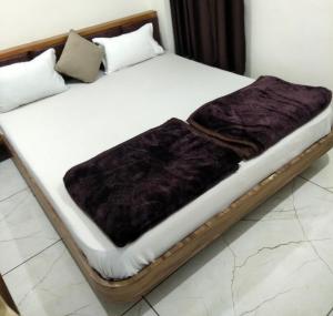 艾哈迈达巴德Hotel Milan的一张木床,上面有紫色毯子