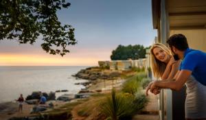 诺维格勒伊斯特拉Amber Sea Luxury Village Mobile Homes的站在一个看海洋的房子外的男人和女人