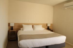 康塞普西翁Hotel Umawue的一间卧室配有带白色床单和枕头的床。