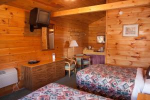 潘圭奇Bryce Gateway inn Cabins的一间卧室配有两张床和一张书桌及电视