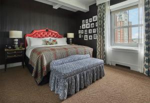 普罗维登斯Graduate Providence的一间卧室配有一张带红色床头板和长凳的床