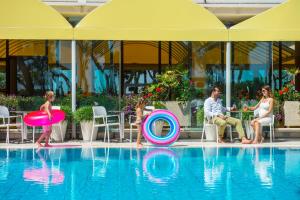 朱利亚诺瓦帕克德普林西比酒店的一家在度假村的游泳池玩耍