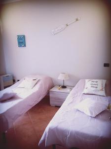 维拉西米乌斯Casa Sù Flamingo的两张睡床彼此相邻,位于一个房间里
