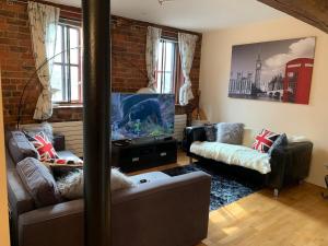 利物浦2 Bed Duplex Penthouse Apartment by Mathew Street Sleeps 6的客厅配有2张沙发和1台平面电视