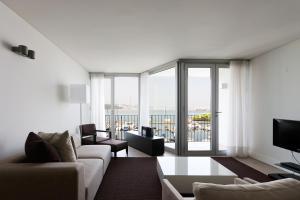 特罗亚Troia Residence by The Editory - Apartamentos Marina的带沙发和大窗户的客厅