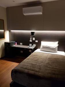 圣达菲Hotel Riogrande - Habilitado的一间卧室配有一张床和一张带白色枕头的书桌