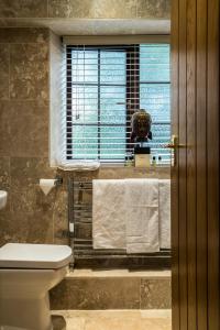韦克菲尔德妙思酒店的一间带卫生间、窗户和毛巾的浴室