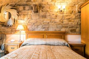 韦克菲尔德妙思酒店的一间卧室设有一张床和石墙