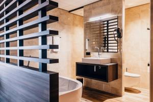 霍赫芬霍赫芬酒店的浴室配有盥洗盆、卫生间和浴缸。