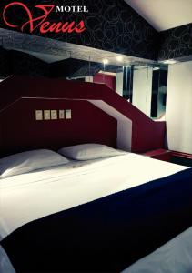 贾拉普Auto Hotel Venus的一间卧室配有一张大床和红色床头板