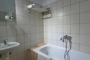EleftheroúpolisPravi Hotel的带浴缸和盥洗盆的浴室