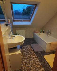 克桑滕Inseldorf Wardt的一间带水槽和浴缸的浴室以及窗户。