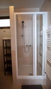 海吉克莱文杜洛公寓酒店的浴室里设有玻璃门淋浴