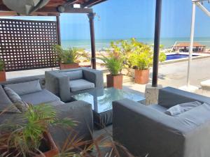 卡塔赫纳Penthouse Caribbean View and private pool, Cartagena的一个带沙发和桌子的庭院和海滩
