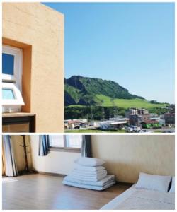 西归浦市城山早晨日落度假屋的客房设有一张床和享有山景的窗户