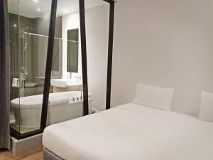 莱卡邦Vismaya Suvarnabhumi Hotel的一间卧室配有一张床、一个浴缸和一个水槽