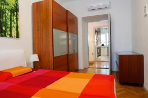 卢布尔雅那Tomas's apartment的一间卧室配有一张色彩缤纷的床和一个木制橱柜