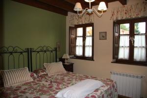 努埃瓦德兰斯Hotel rural La Llastra的一间卧室设有一张床和两个窗户。