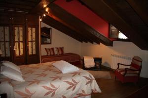 努埃瓦德兰斯Hotel rural La Llastra的一间卧室配有一张大床和一把椅子