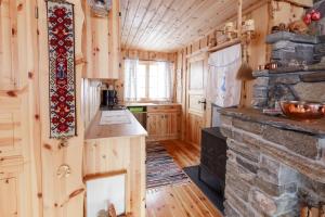 斯特兰达Langlofonna的小木屋内的厨房设有石制壁炉
