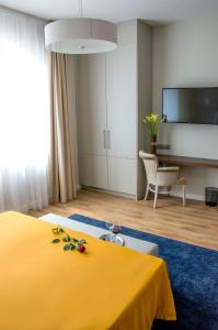 帕波Ditlin的酒店客房设有一张黄色的床和一台电视。
