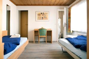萨沃宁B&B La Tgamona的一间卧室配有两张床和一张桌子及椅子