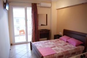 奥林匹亚基·阿克蒂玛丽克莱尔一室公寓的一间卧室配有带粉红色枕头的床和窗户。