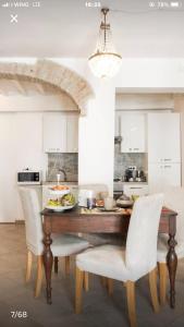 帕尔马Il Tenore d'Oro Centralissimo的厨房配有木桌和白色椅子