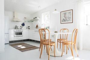 莫勒松德Kvarnstugan的白色的厨房配有木椅和桌子